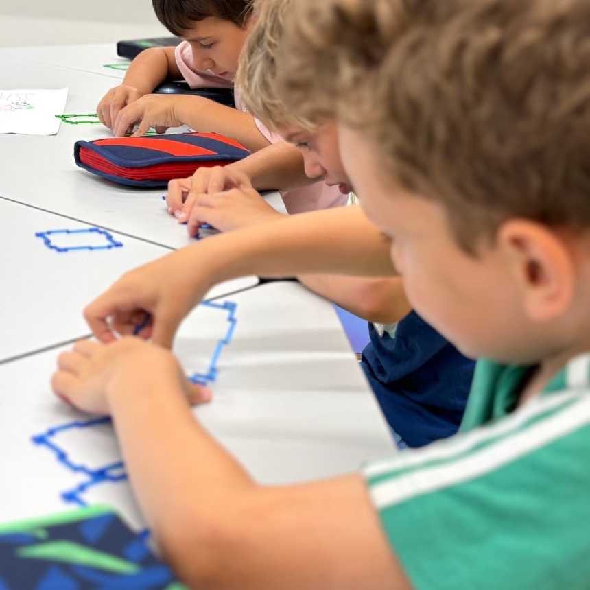 Kinder basteln Geometrische Formen mit Garn und kleben dieses auf Papier